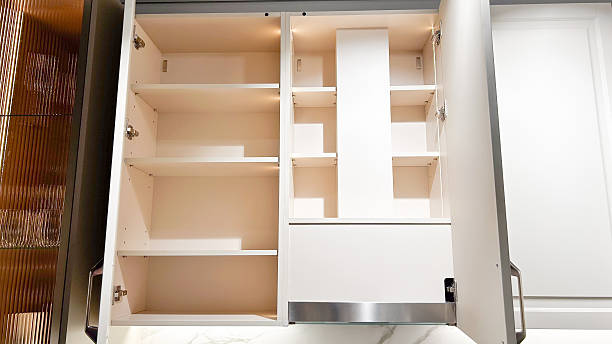 istock New bright white kitchen wall cabinets with open doors, showcasing empty illuminated shelves 2253276972
