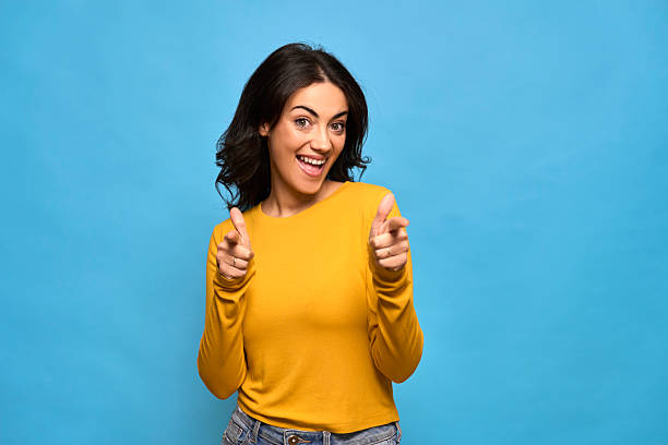 istock Happy woman pointing finger guns at camera 2253277855