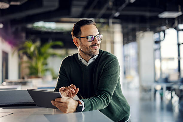 istock Mid-adult businessman using digital tablet in modern office 2253278305