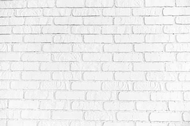 istock Clean white painted brick wall textured background with subtle shadows creating depth and character. 2253278389
