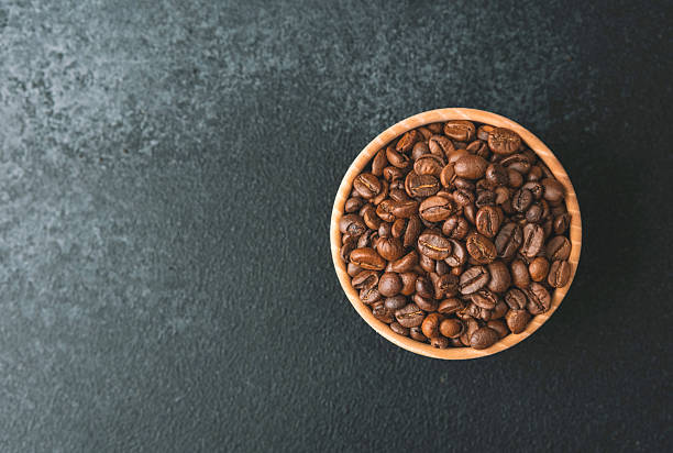 istock Coffee beans in wooden bowl on dark background 2253278475