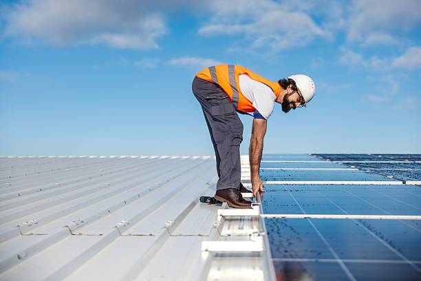 istock Technician installing solar panels on rooftop maintaining green energy 2253278669