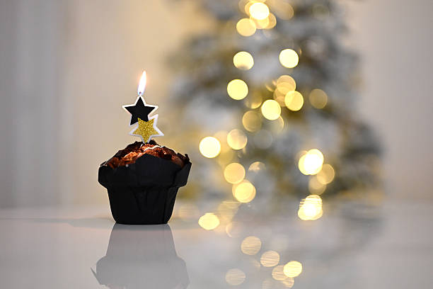 Cupcake with star candle against blurred festive lights