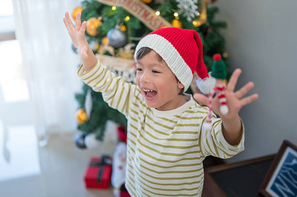 istock excited child celebrating with santa hat 2253279745