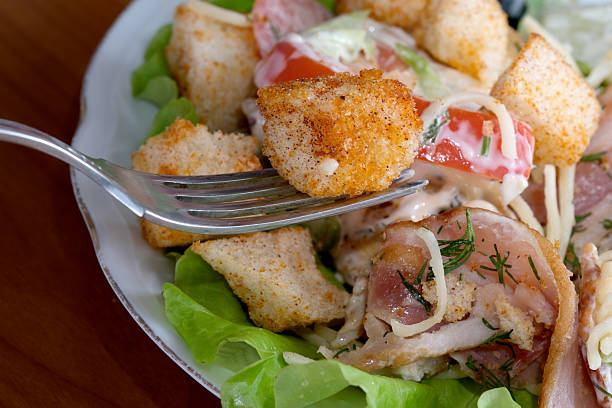 A mixed salad featuring vibrant vegetables and golden croutons on a cozy table.