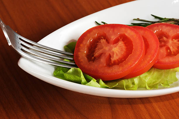tasty red tomatoes and lettuce on the table