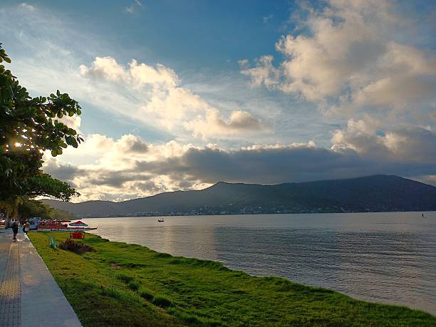 istock Panoramic landscape of a calm lake with mountains in the background under a dramatic cloudy sky. 2253280965