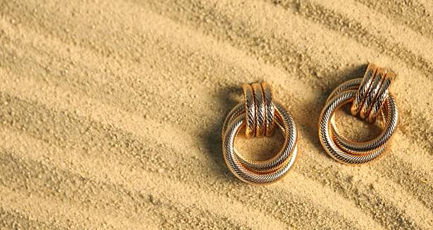 Brass earrings with pearl on a black slate with copy space.