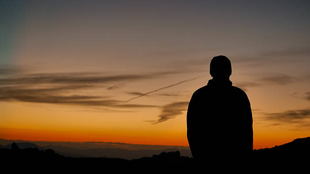 istock Silhouette of a person watching a dramatic sunset over mountain landscape 2253283328