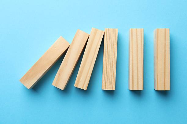 istock Risk. Wooden blocks falling on light blue background, flat lay with space for text 2253283565