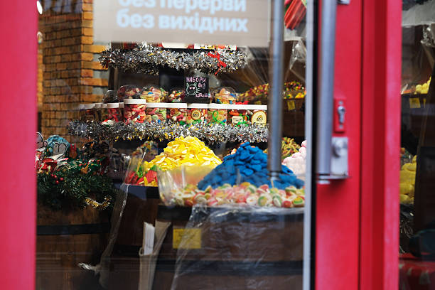 Bright sweets and candies create a delightful scene in a shop window. Podil, Kyiv, Ukraine. December 8, 2025.