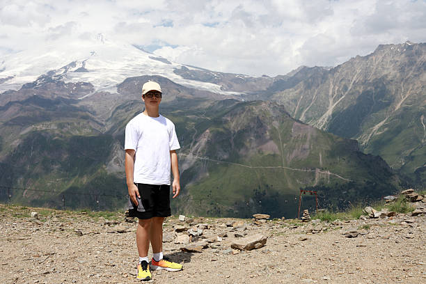 istock Young man posing near snow-capped mountains on Mount Cheget 2253284799