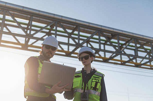 istock Industrial Engineers Inspecting Construction Site with Laptop, engineering teamwork, industrial inspection, project management and modern construction technology. 2253286303