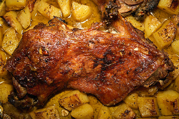 Roasted lamb mutton whole leg in a baking dish.  Isolated, white background