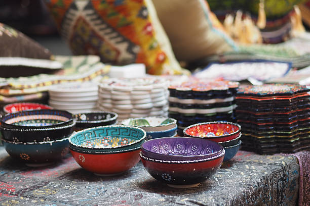 Colorful bowls are displayed on a table at a local craft market.