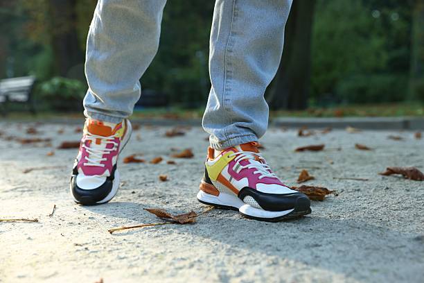istock Man in stylish sneakers walking on asphalt outdoors, closeup 2253292192
