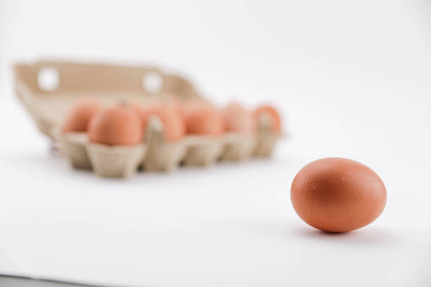 A Close-Up View Of Brown Eggs Arranged In A Recycled Cardboard Carton On A White Background, Showcasing Natural Texture And Packaging For Food And Grocery Themes.