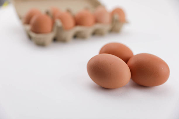 A Close-Up View Of Brown Eggs Arranged In A Recycled Cardboard Carton On A White Background, Showcasing Natural Texture And Packaging For Food And Grocery Themes.