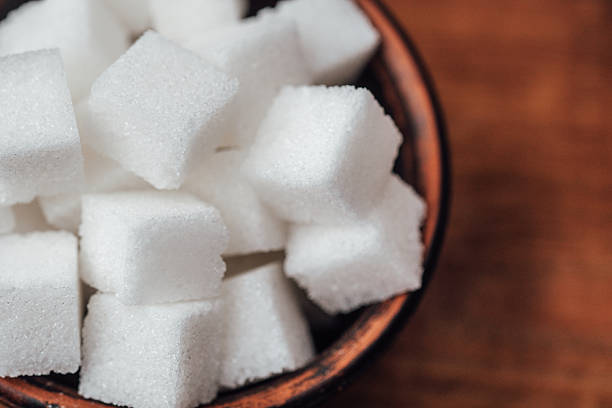 istock Sugar cubes arranged in a brown bowl on a wooden surface 2253293535