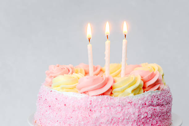 istock Celebrating a special birthday with a pink cake adorned with candles 2253293941