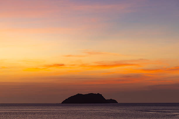 istock Silhouetted Island on the Horizon at Sunset 2253294712