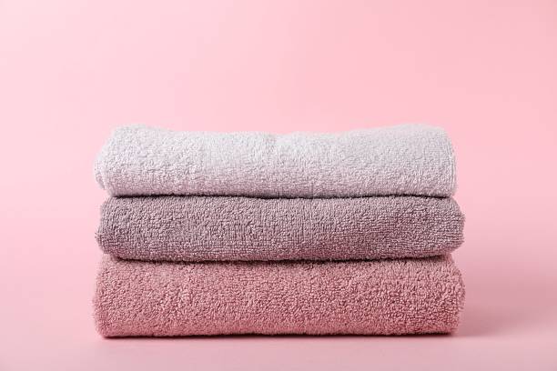 istock Stack of fresh terry towels on pink background 2253295325