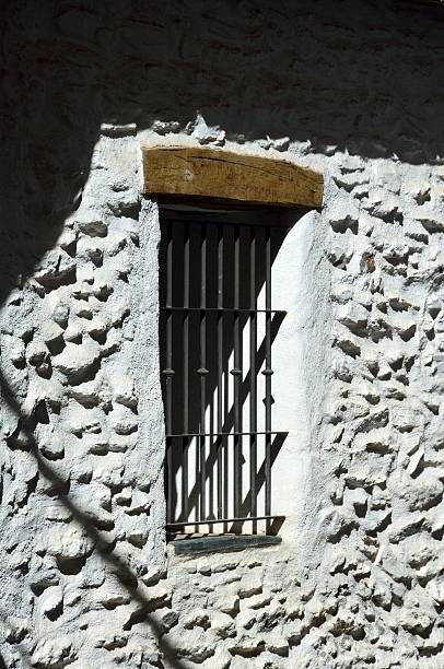 istock Window with iron bars on a whitewashed wall in Pampaneira 2253297046