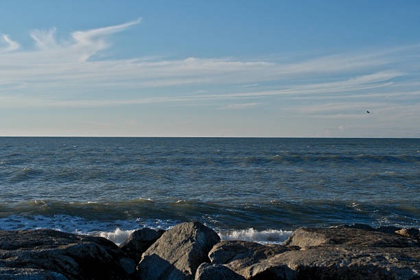 Rocky Black Sea Shore under Blue Sky with Clouds. Black Sea Horizon: Rocks, Waves and Vast Blue Sky