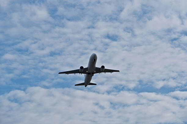 istock Airplane in the cloudy sky. White Plane Climbing Through Clouds Half a Minute Post-Takeoff. 2253300671
