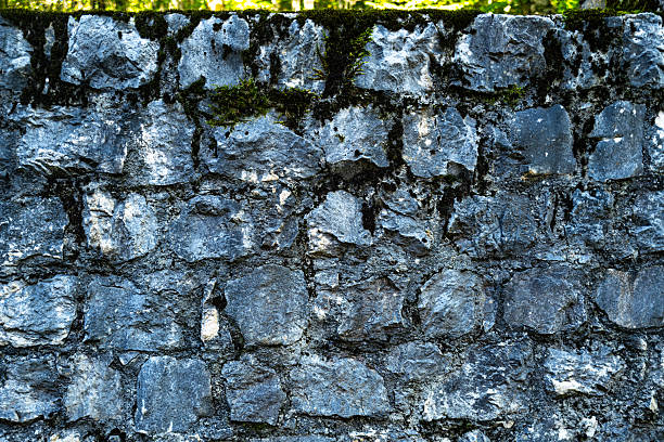 Old stone background with rustic texture. Historic stone wall background in architecture. Aged stone surface as background. Textured old stone blocks background