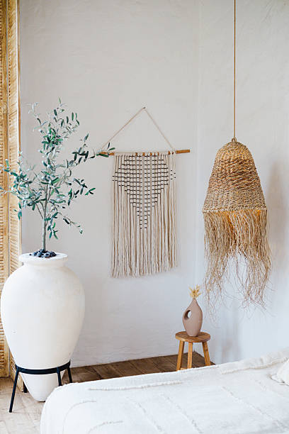 istock Warm boho room decor with large white pot plant, macrame wall hanging, woven light, and ceramic vase. 2253302997
