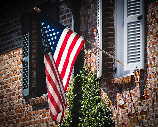 An American flag, flying from an old brick building, on Queen Street in Charleston, South Carolina.