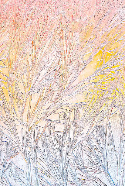 istock Abstract frosty pattern on glass in warm sunrise colors, with icy branches and gradient from soft pink to yellow and pale blue. Delicate winter texture with artistic, dreamy atmosphere 2253303262
