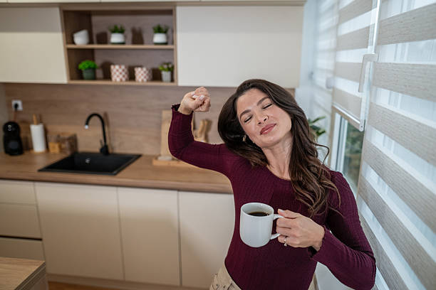 istock Woman stretching in kitchen enjoying morning coffee 2253303760