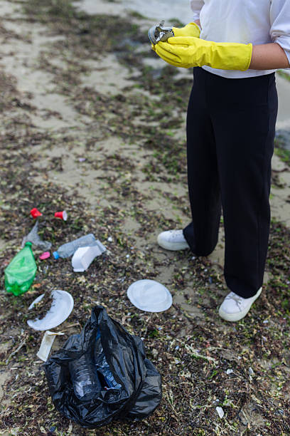 istock volunteer cleaning polluted beach, collecting 2253304713
