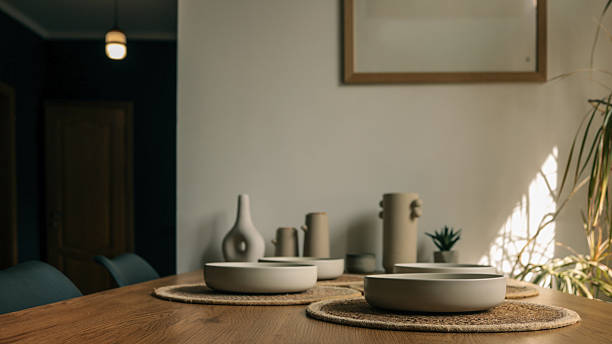 istock Modern dining table setting with minimalist ceramic bowls and vases bathed in sunlight 2253305197