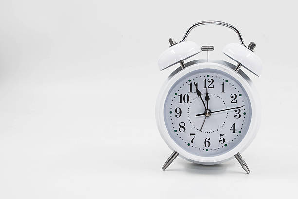 istock White alarm clock showing time isolated on light background for schedule planning concept 2253307120