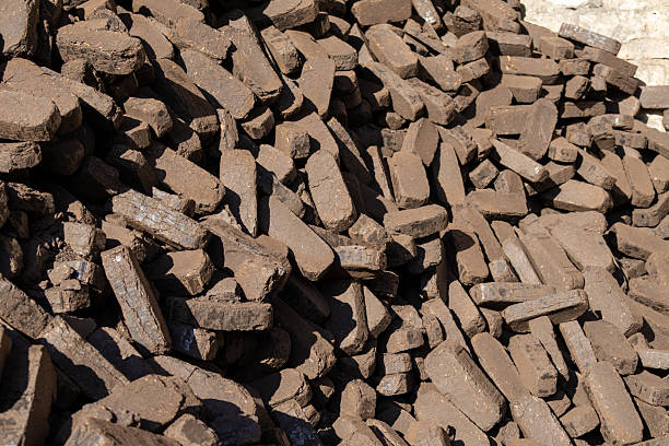 istock Brown clay bricks are piled high at a construction site. The sun shines brightly on the bricks creating shadows 2253307306