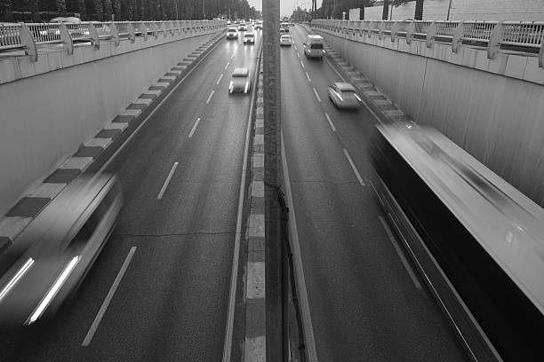 On a divided highway, vehicles are moving in a blurry manner.