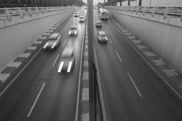 On a divided highway, vehicles are moving in a blurry manner.
