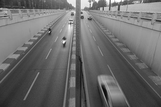 On a divided highway, vehicles are moving in a blurry manner.