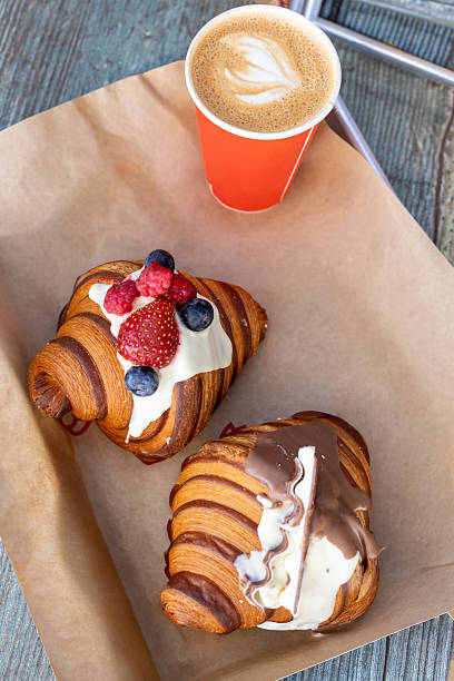 istock Artisan croissants with cream and fresh berries in bakery display 2253309283