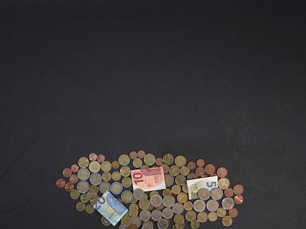 Concept of wealth, savings, and Eurozone finance. Euro banknotes and coins stacked with negative space for advertisements
