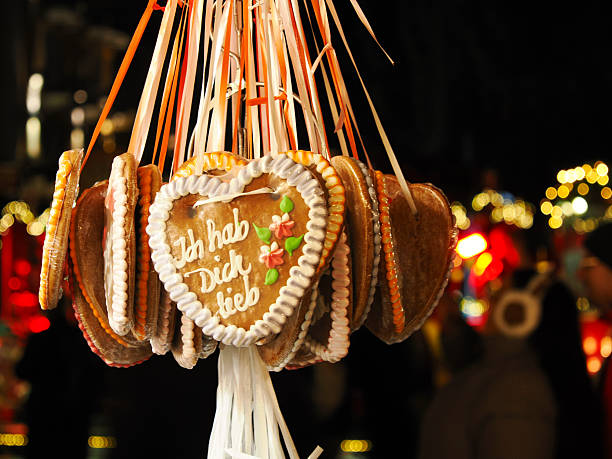 Traditional German gingerbread hearts hanging at festive Christmas market with colorful lights