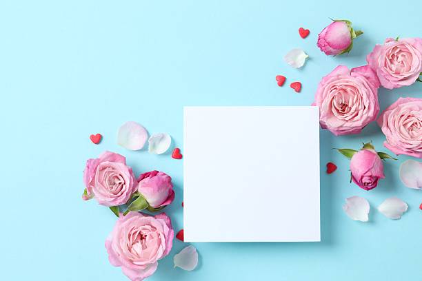 istock Beautiful composition with pink roses and white paper card on blue background 2253312336