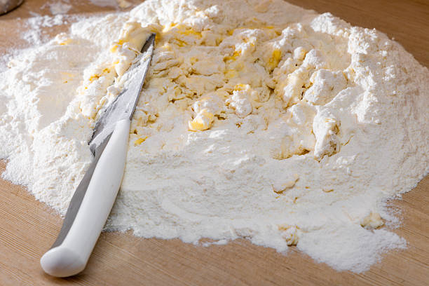 Kneading traditional dough for meat dumplings for Christmas, making dough with flour, eggs, and butter, in the kitchen, realistic photos