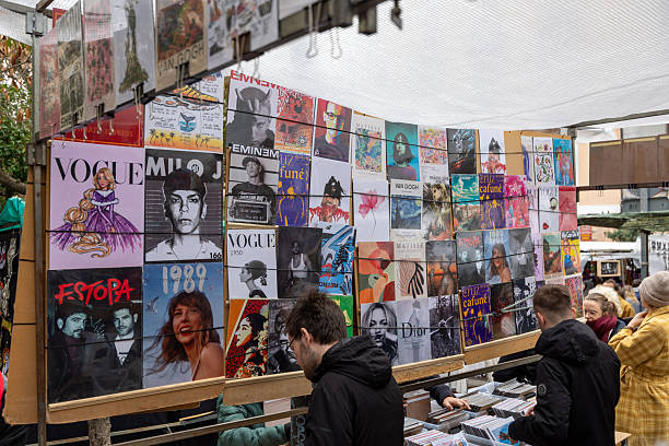 Madrid, spain; 11 15 2025 shoppers looking at retro album covers and pop culture posters at a market stall