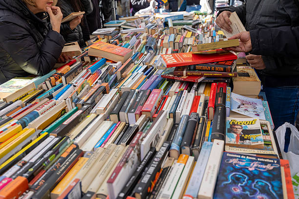 Madrid, spain; 11 15 2025 people browsing and selecting second-hand books at a street stall in el rastro flea market