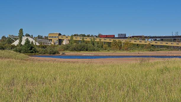 Freight trains load iron ore into shoots on ore dock for loading a massive Great Lakes shipping freighter