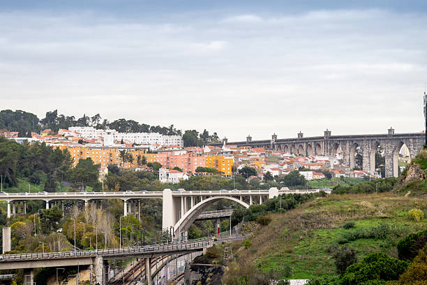 Lisbon Portugal December 06 2025. Multiple highway bridges span a railway valley surrounded by trees and residential neighborhoods under an overcast sky.